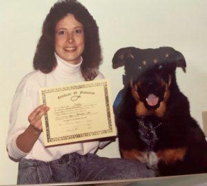 Donna Bloniasz, holding a certificate, poses with Buddy, a Rottweiler-German shepherd 