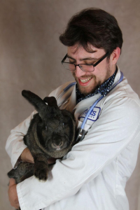 Jason Doll with his white coat on holding a big rabbit