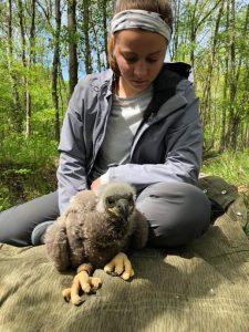 Kristen Bishop sitting examining a baby eagle