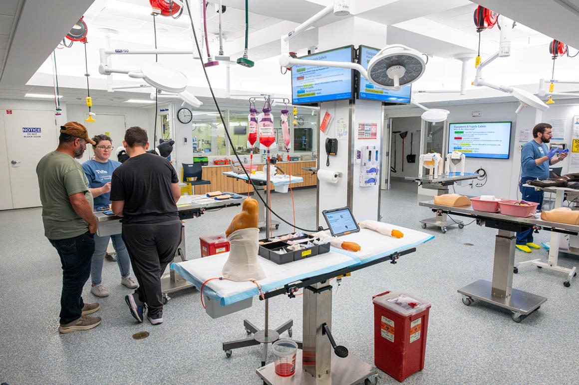 Individuals stand inside a teaching laboratory with simulation models.