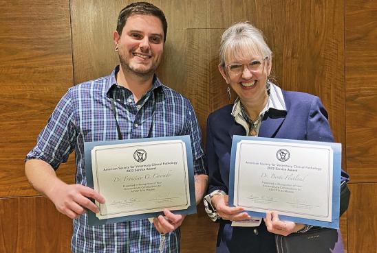 Cummings School’s Dr. Francisco Conrado and the University of Tennessee’s Dr. Bente Flatland holding their 2022 ASVCP Service Awards.