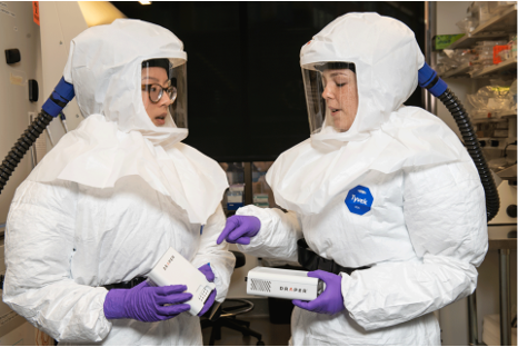 two female scientist wearing biosafety gear