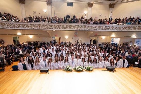 Students pose for a class photo after receiving their white coats. 