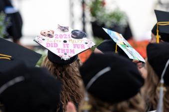 decorated graduation caps being worn by graduating students.
