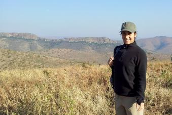 Person smiling and standing in a mountain at KwaZulu-Natal, South Africa.