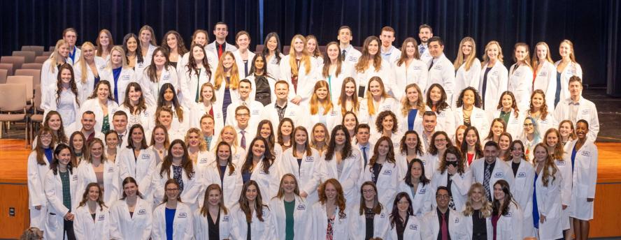 Class stands for photo in their white coats