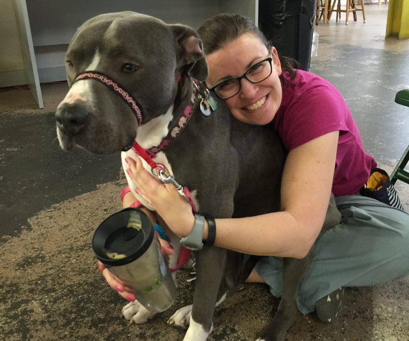 Sandra Robbins, a veterinary technician and behavior trainer at Foster Hospital for Small Animals hugging her pitbull names Amelia