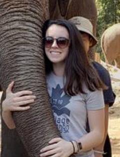 Catherine Cummings hugging an elephant's trunk