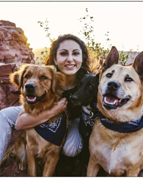 Woman sitting and hugging her 3 dogs, Ariana Marangakis, VG23