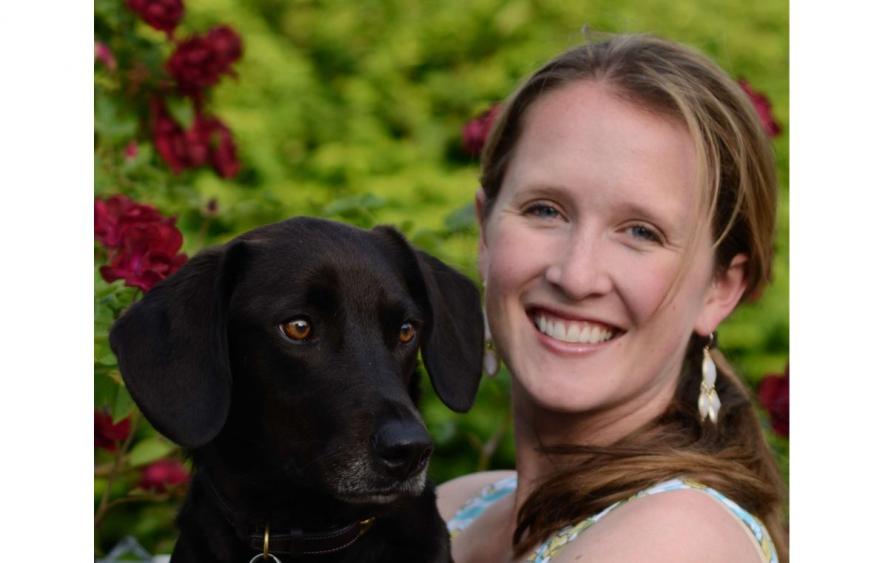 Woman holding a brown dog.