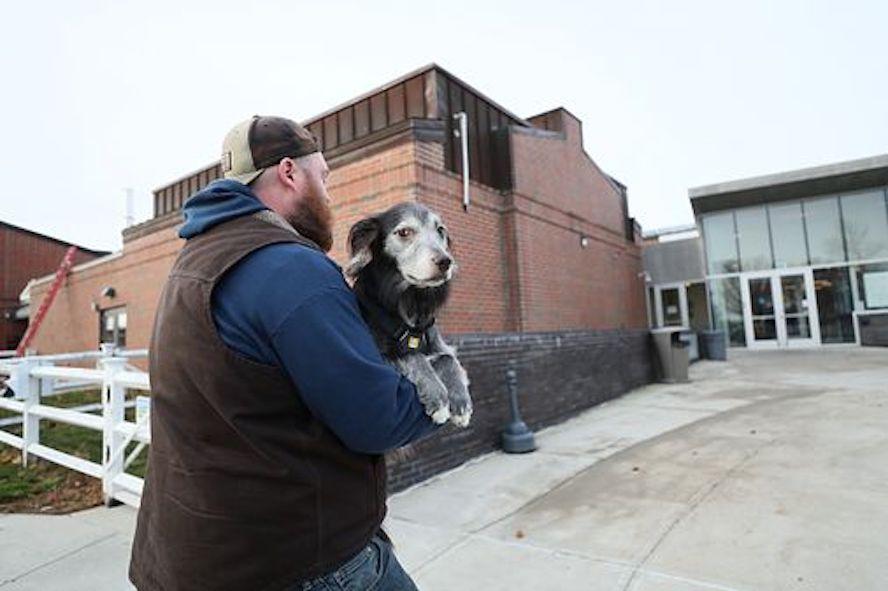 Man carrying his dog into Foster Hospital for Small Animals in North Grafton, MA