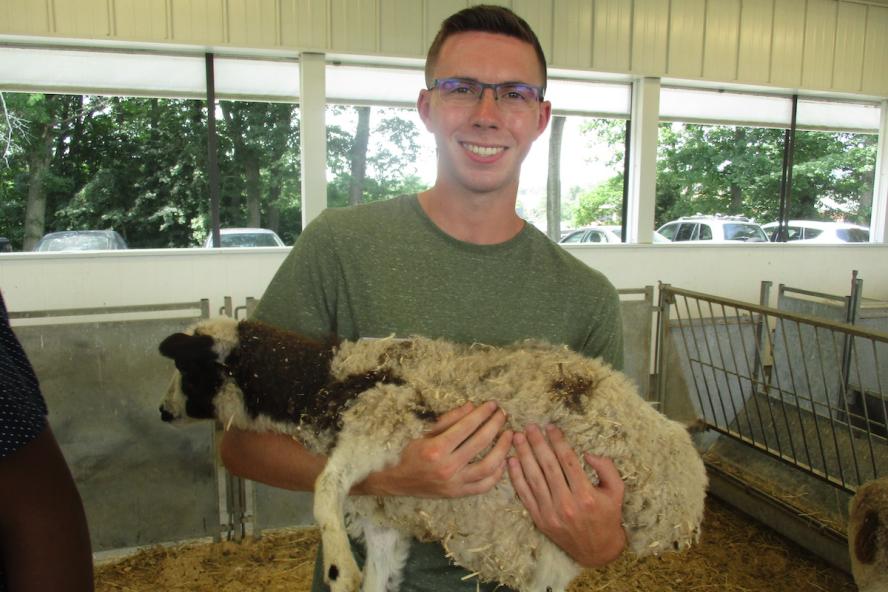 a college student holding a sheep.