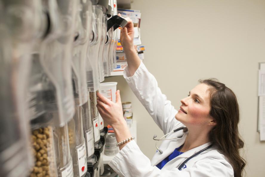 person dispensing dog food in a veterinary nutrition center