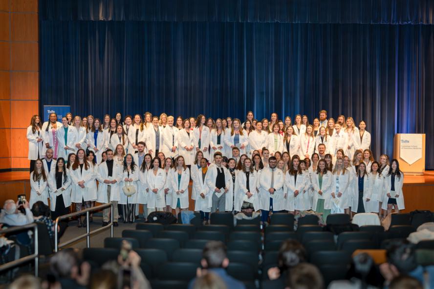 Students pose for a class photo after receiving their white coats