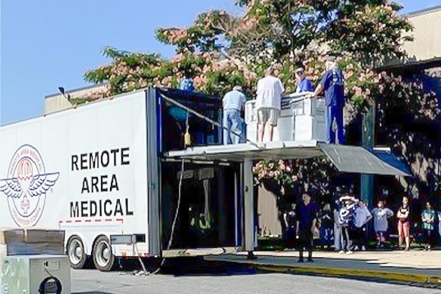 Remote Area Medical truck with people gathered around.