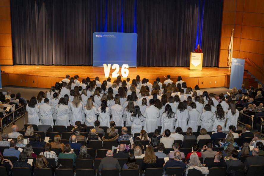 The class of V26 veterinary students, standing facing the stage, received their white coats and recited the veterinary oath. 
