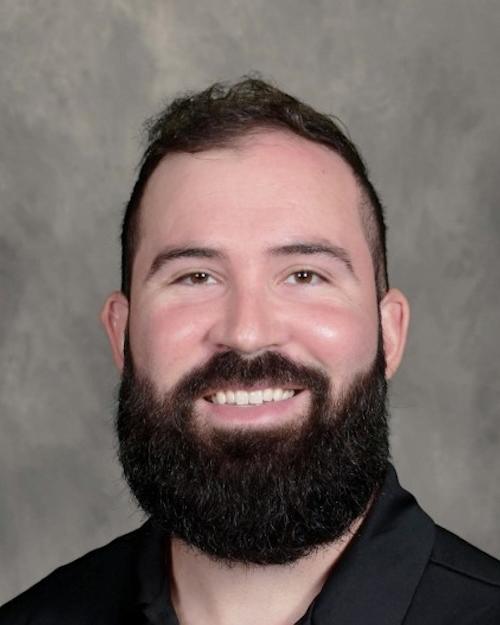 Alex Garcia. A person with short dark hair and a dark beard and mustache wearing a black shirt.