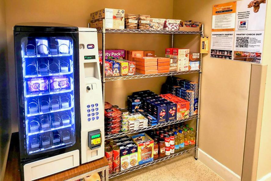 Four wire shelves with boxes of different foods on them like pasta and oatmeal.