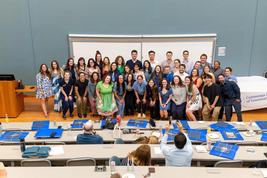 44 people posing for a photo in a lecture hall