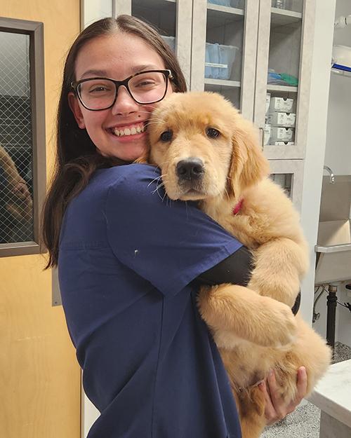 Ashley Berthiaume holding a puppy golden retriever