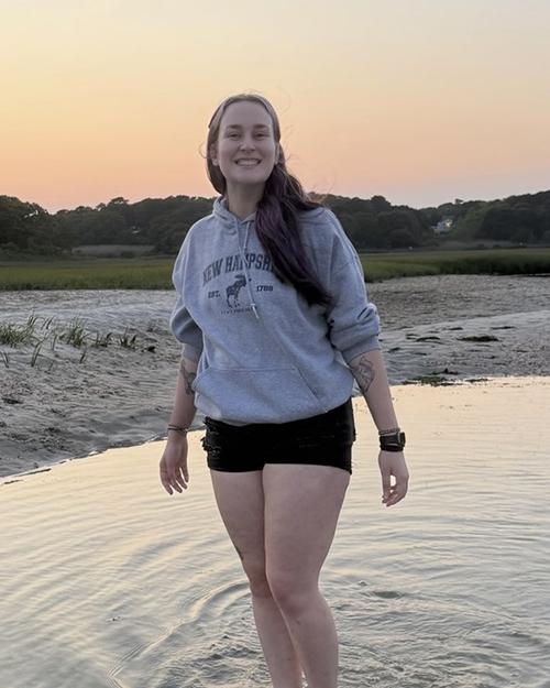 Dakota Incorvaia standing in water with a sunset behind her.