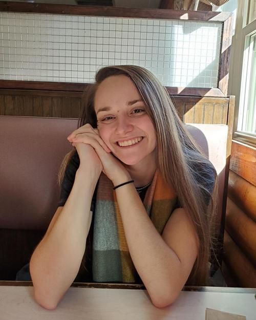 Kirsten Krause sitting in a restaurant booth posing for a photo.