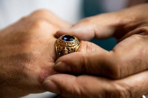 A man’s class ring on a hand.