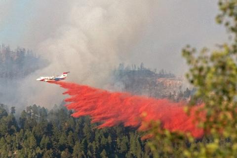 Fire retardants being sprayed from a jet over wildfires in California