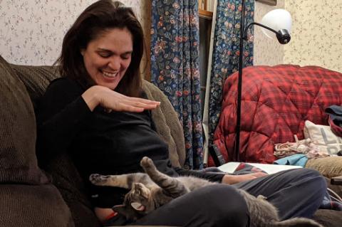  Michelle Emmott plays with a pet cat on the couch