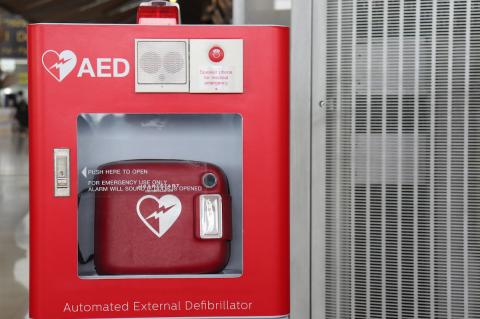 red automated external defibrillator with an emergency call button.