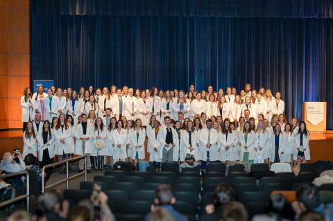 Students pose for a class photo after receiving their white coats