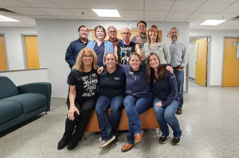 A group of people gathered in a lobby to take a group photo.
