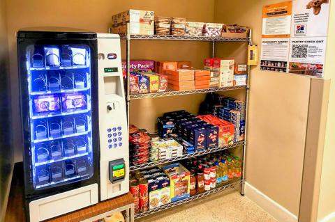 Four wire shelves with boxes of different foods on them like pasta and oatmeal.