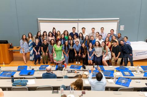 44 people posing for a photo in a lecture hall